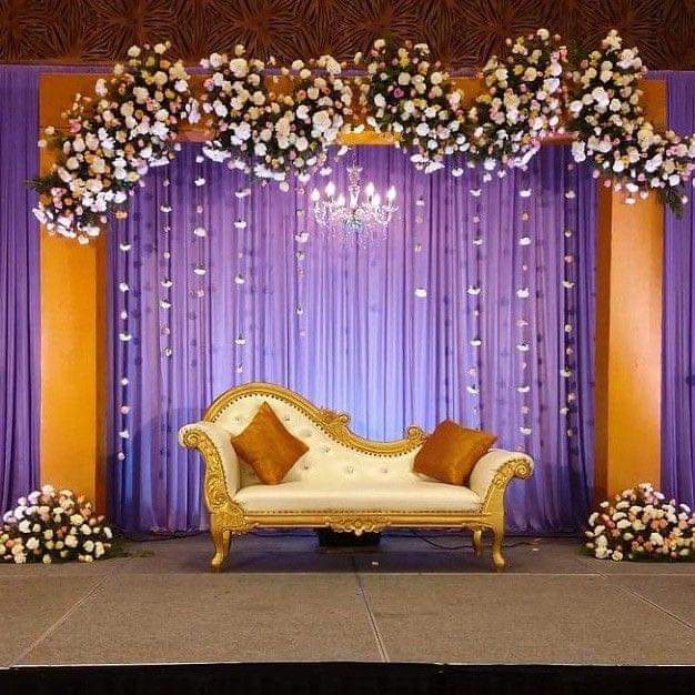 Luxury event decoration with floral backdrop and chandelier lighting by Oikar Events